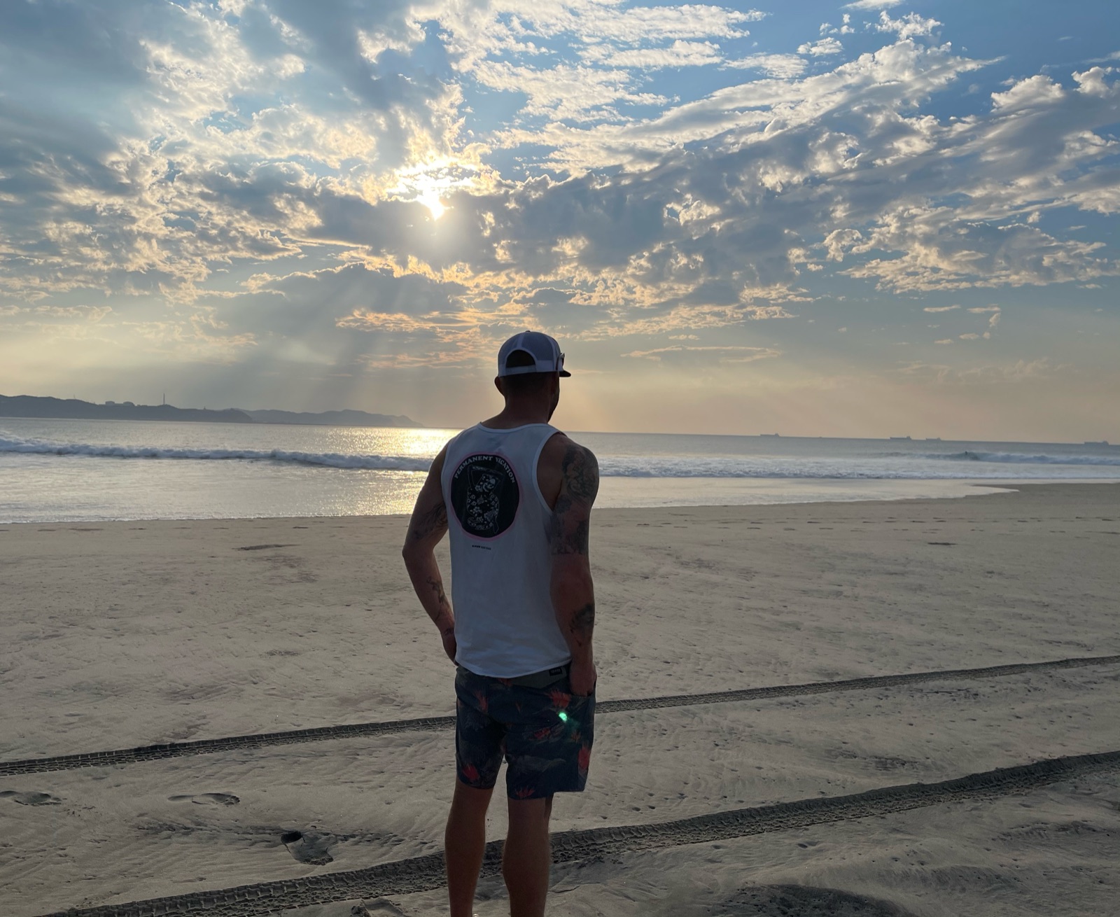Charles on the beach at sunset, looking out at the ocean