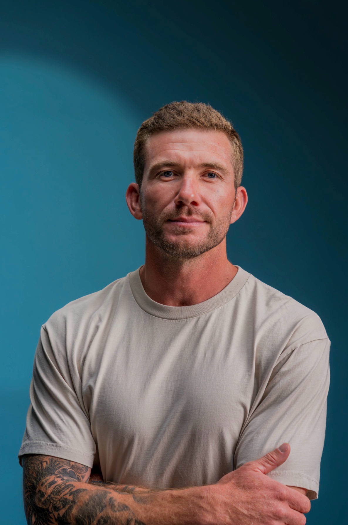 Portrait of Charles Boucher in a light T-shirt, arms crossed, with a calm half-smile