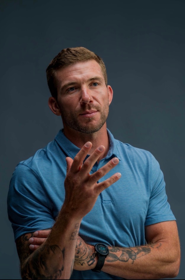 Charles in a blue polo, hand raised mid-thought